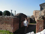 Maggie wandering between ruins.  The Romans used brick and mortar extensively.   Often bricks were laid with mortar as forms for an interior of concrete.  The disappearance of Roman power in western Europe during the 5th century led to a decline in building technology. Brickmaking became rare and was not revived until the 14th century. Concrete disappeared entirely, and it would not be until the 19th century that man-made cements would equal Roman concretes. We've read that Roman bricks were most often triangular and were laid apex inward, but we haven't been able to see this on our own.