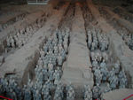 Some of the 6-8 thousand soldiers.  No one is certain that all the soldiers have been found.  The buried army faces east, poised for battle, about three-quarters of a mile from the outer wall of  Shih huang-ti's tomb. In pits nearby have been found the remains of seven humans (possibly the emperor's children), a subterranean stable filled with horse skeletons, an assemblage of half-size bronze chariots, 70 individual burial sites, a zoo for exotic animals, and other artifacts.  Today, most of the surface area consists of farm fields, buildings, roads, etc.