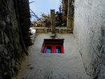 Bright window in a mud-colored village