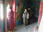 Kids interpreting painting while monk looks out the window