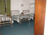A neighboring room with what appear to be hospital beds.  You might be able to see that the middle bed has a distinct headward slant to it.